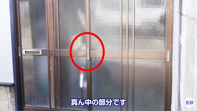 横にスライドするタイプの引き戸の中央についている縦型の鍵を示す写真
